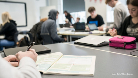 Store skolebørn sidder i klasse